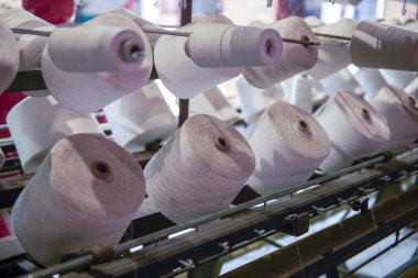 Pamuk çevirme makinesinde bir sıra bobin.