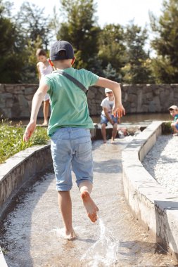 Mutlu çocuklar parkta koşup oynuyorlar.