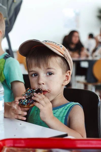 Мальчик Ест Разноцветный Пончик — стоковое фото