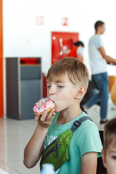 Ragazzo Mangiare Una Ciambella Colorata — Foto Stock