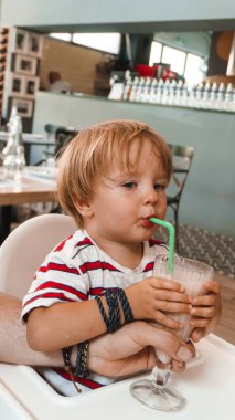 Küçük çocuk şişeden su içiyor.