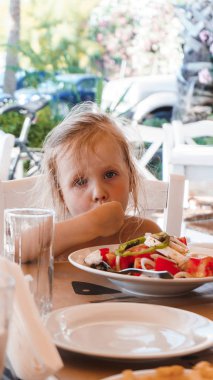 Küçük tatlı kız lezzetli bir pasta yiyor.