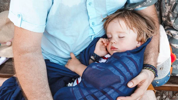 かわいい眠っている息子を屋外に運ぶ父親のクロップドショット — ストック写真