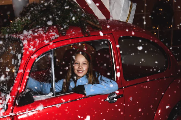 Χριστούγεννα Μικρό Κορίτσι Που Κάθεται Ένα Κόκκινο Αυτοκίνητο Κάτω Από — Φωτογραφία Αρχείου