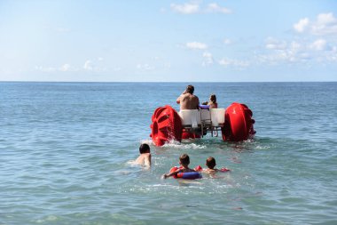 Sudaki ve dalgalardaki bir grup insan, yaz tatili