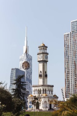 Arka planda modern mimari binası ve şehir manzarası var.