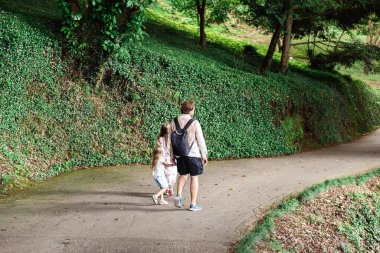 Baba ve kızları parkta yürürken arka plan görüntüsü 