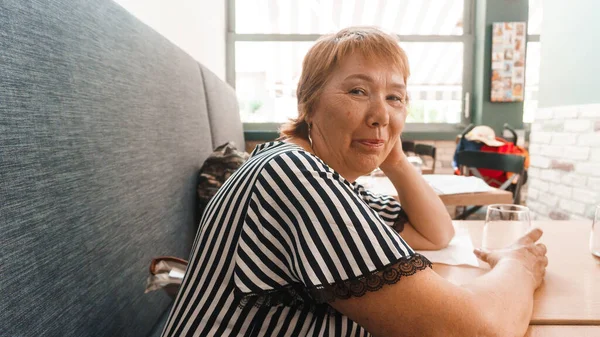 Senior Vrouw Zitten Aan Tafel Kijken Naar Camera — Stockfoto