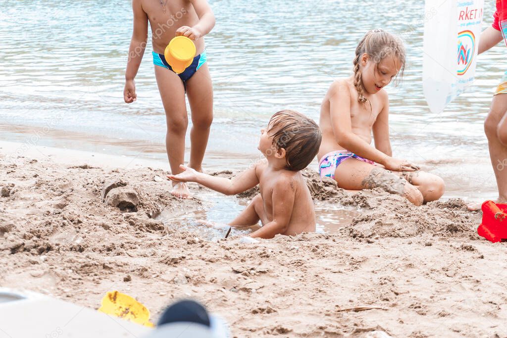 children playing with toys on sandy beach