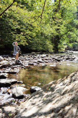 Genç kız Rapid nehrinin yanında yürüyor. Güzel manzara