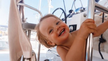 Sevimli mutlu çocuk yatta oynuyor.