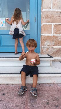 Küçük şirin çocuklar yazın şehirde dondurma yiyorlar.