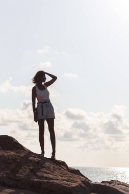 Kumsalda sırt çantalı genç bir kadın.