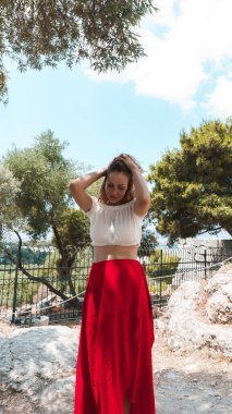 Kumsalda poz veren kırmızı elbiseli güzel bir kadın. 