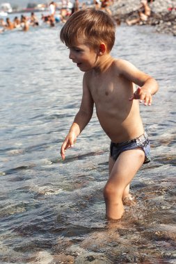 küçük çocuk su sahilde oynarken