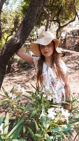 Mädchen Mit Hut Auf Einem Hintergrund Aus Blumen — Stockfoto