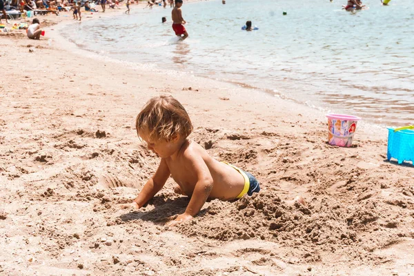 小さな男の子が砂浜で遊んでいる — ストック写真