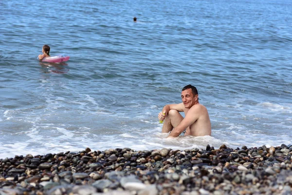 Homem Feliz Sentado Seixos Ondas Mar — Fotografia de Stock