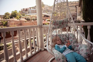 Küçük kız salıncakta dinleniyor.