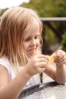 Küçük kız bir dilim limon yiyor.