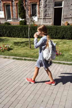 Şehirde dolaşan ve maden suyu içen bir kız.