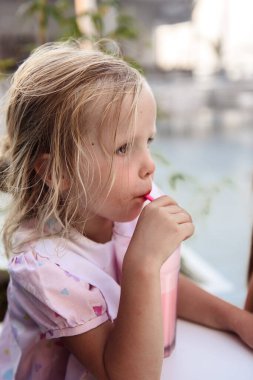 Güzel küçük kız süt kokteyli içiyor.