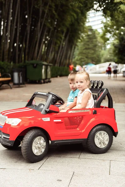 Küçük Bir Çocuk Kız Oyuncak Bir Arabaya Biniyorlar — Stok fotoğraf