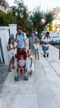 Büyük bir aile yaz şehrinde yürüyor.