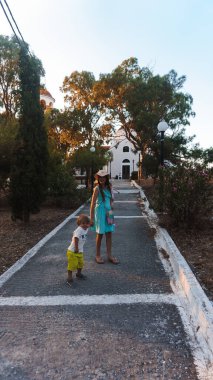 Aile Yunanistan adalarında yürüyor. Ağaçlar, taşlar