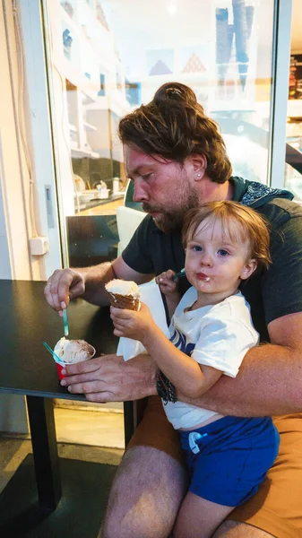 Dad and son eating ice cream in a cafe