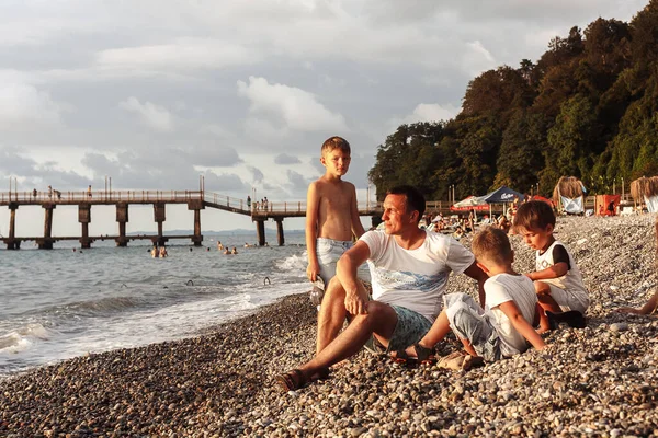 Aile Gün Batımında Deniz Kıyısında Oturuyor — Stok fotoğraf