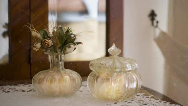 Romantyczna scena zamyka świecę migoczącą w luksusowym szklanym wazonie. — Wideo stockowe
