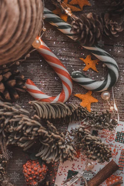  Tahta arka plandaki Noel süsleri oyuncaklar Noel ağacı konileri lolipoplar pullar