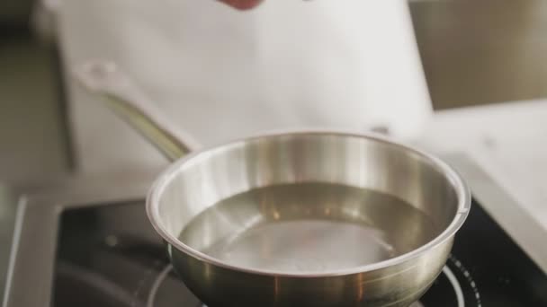 Closeup cook man salting boiling water — Αρχείο Βίντεο