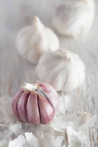 Group of garlics on white wood. Close-up — Stock Photo, Image