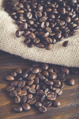 Kahve çekirdekleri çuval bezi kumaş ve ahşap arka plan
