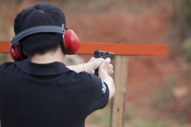 Bir tabanca atış yapmaya hazır onun elinde tutan adam