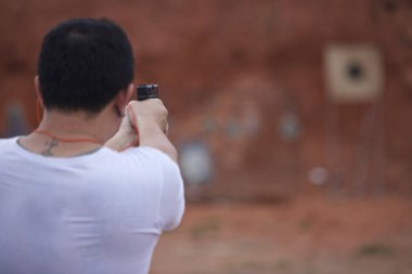 Bir tabanca atış yapmaya hazır onun elinde tutan adam