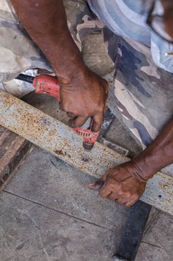 İnşaat işçileri iş oluşturmak için bir matkap kullanarak.