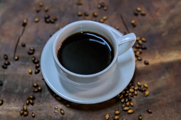 Café negro en una taza blanca puesto en una vieja mesa de madera —  Fotos de Stock