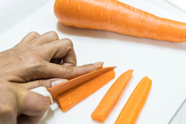 Zanahorias en rodajas con cuchillo aislado sobre fondo blanco — Foto de Stock