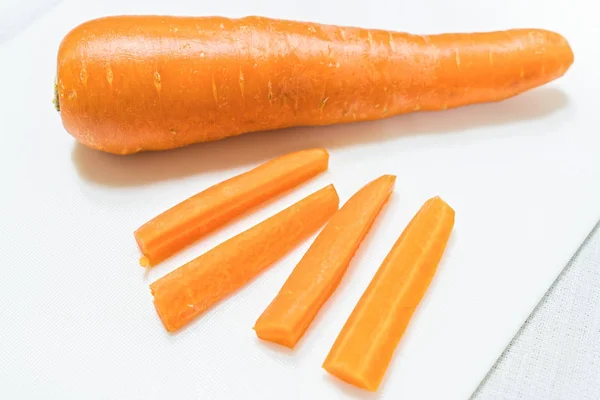 Нарезанная морковь с ножом изолированы на белом фоне — стоковое фото