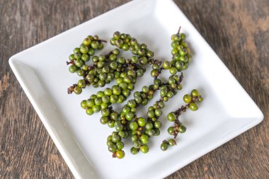 Karabiber ahşap bir masa üzerinde beyaz bir plaka yerleştirilir.