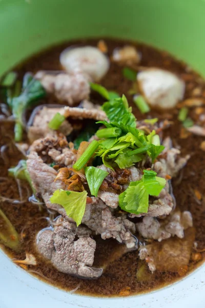 Ahşap bir masa üzerinde bir kase erişte topları vardır.