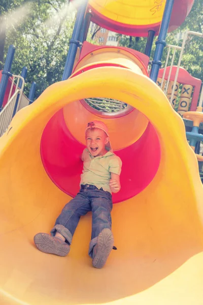 Netter Junge spielt im Tunnel auf Spielplatz — Stockfoto