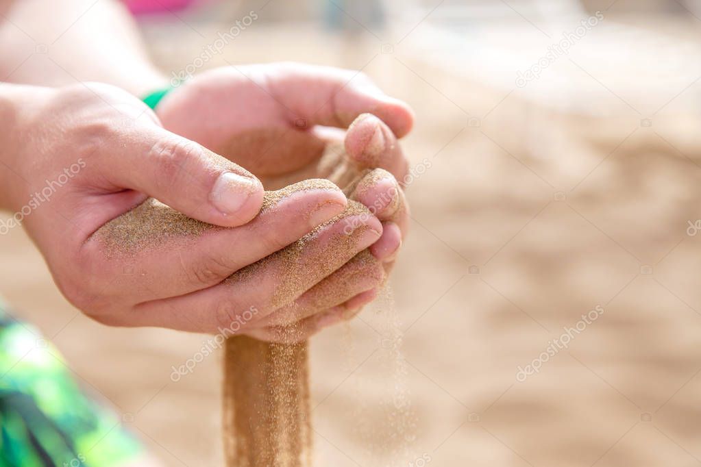 Hands strew sand running