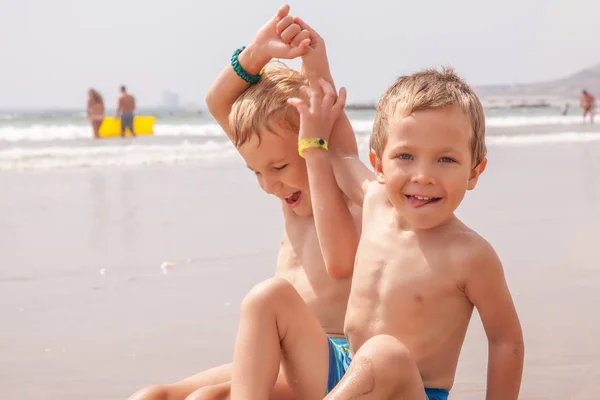 Δύο αγόρια χαριτωμένο αξιολάτρευτο μικρό αδέλφια κάθονται πάνω στη θάλασσα στον ωκεανό παραλία — Φωτογραφία Αρχείου