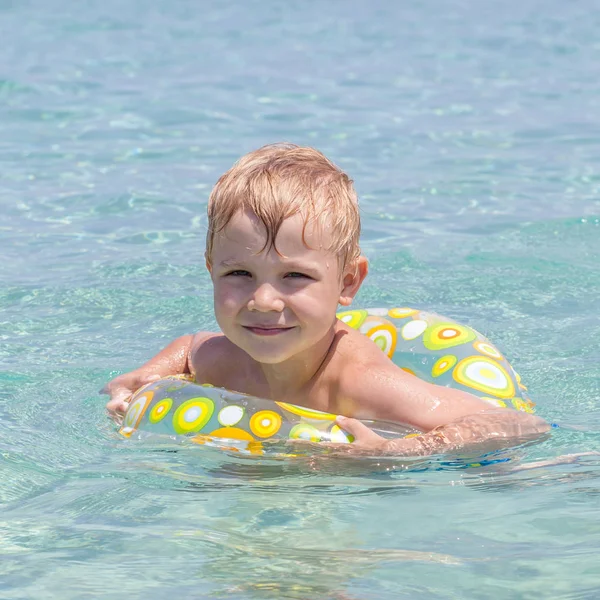 Menino brincando nas ondas no mar em um dia ensolarado — Fotografia de Stock
