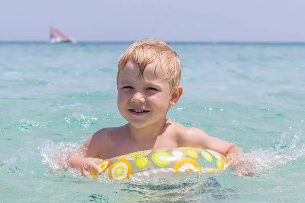 Menino brincando nas ondas no mar em um dia ensolarado — Fotografia de Stock