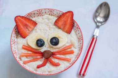 Bir yavru kedi yüz dekorasyonu ile yulaf lapası